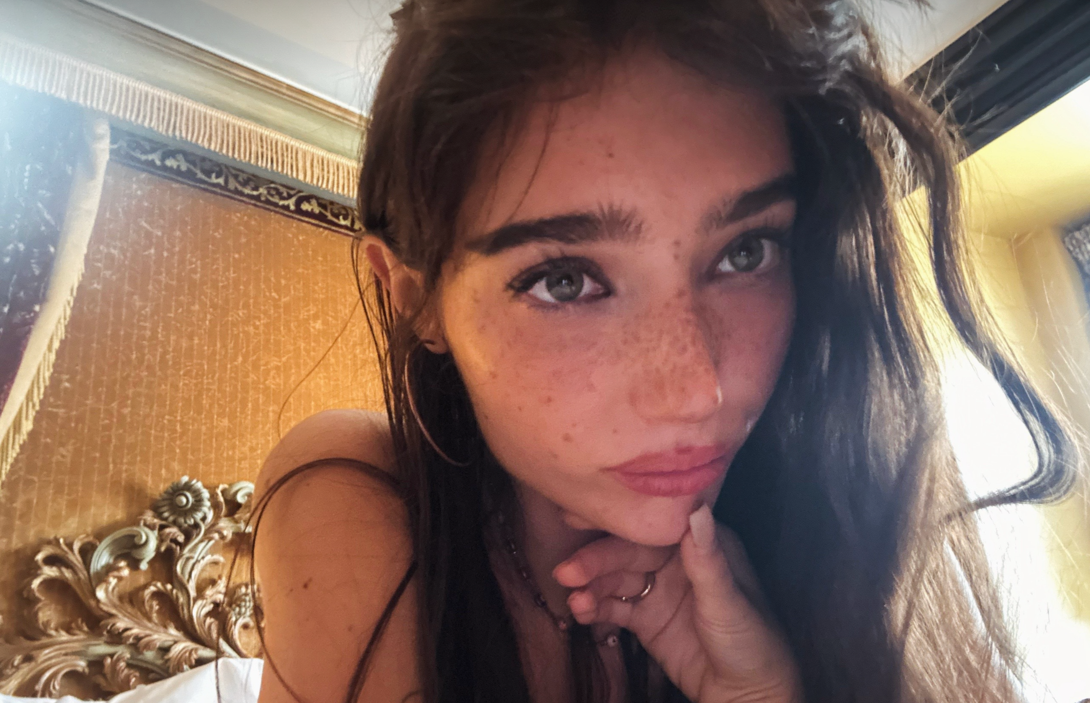 Olivia Cotter @gr8gatsbi selfie in front of a gilded headboard